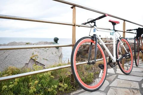 Bicicleta aparcada sobre una barandilla con unas hermosas vistas al mar Stock Photos