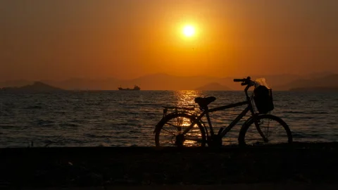 Bicycle on the beach at sunset against the backdrop of the setting sun. Stock Footage 233122476