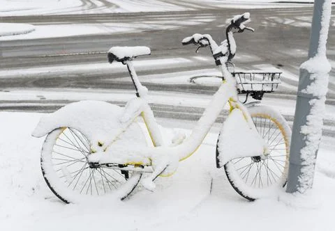 Bicycle bike covered with snow parked by the city road Stock Photos