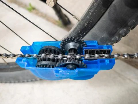 Bicycle chain cleaning tool with rotating brushes in action during bike mai.. Stock Photos