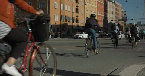 Bicycle commuters crossing an intersection in central Stockholm. Anonymous Video stock 94641413