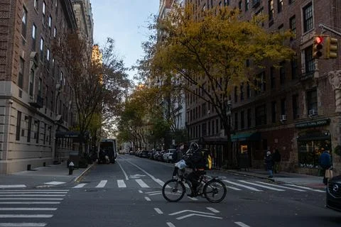 A bicycle courier crossing an intersection on a typical street in New York Stock Photos