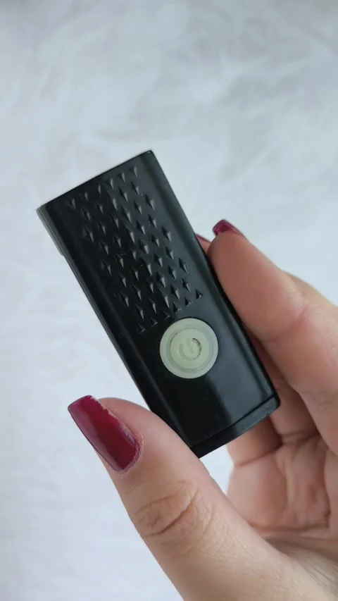 Bicycle flashlight in a womans hand close-up. A woman turns on and off a bicycle Stock Footage 318131164