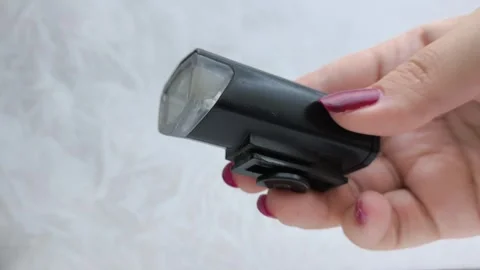 Bicycle flashlight in a womans hand close-up. A woman turns on and off a bicycle Stock Footage 318131285