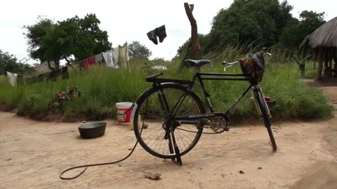 Bicycle In front of a clothesline hanging clothes In Zambia village Stock Footage 196844855