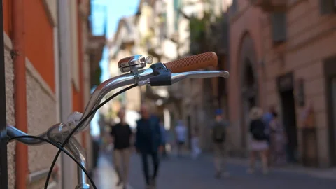 Bicycle handlebars with bell and brown grips overlooking a blurred street Stock Footage 334776264