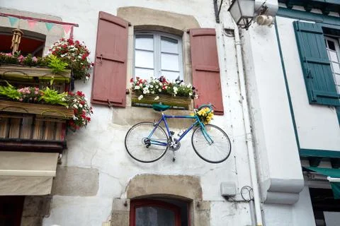 Bicycle hanging on a wall under the window Stock Photos
