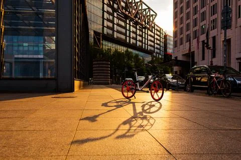 Bicycle in the light of the setting sun. City landscape Stock Photos
