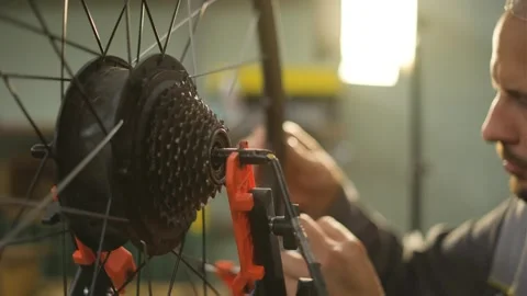 A bicycle master repairs and balances a bicycle wheel. Bicycle service. Stockbeeldmateriaal 282568357