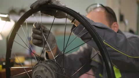 A bicycle master repairs and balances a bicycle wheel. Bicycle service. Stock Footage 302244334