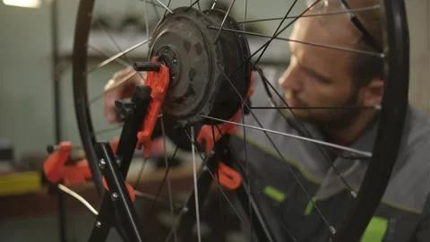 A bicycle master repairs and balances a bicycle wheel. Bicycle service. Stock Footage 302244438