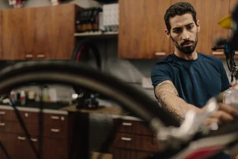 Bicycle mechanic assembling a bike in workshop Stock Photos