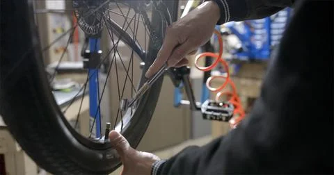 Bicycle mechanic putting air into tire  Stock Photos