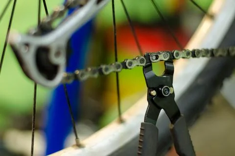 Bicycle mechanic in the workshop in the repair process holds the tool in his  Stock Photos