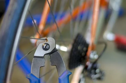 Bicycle mechanic in a workshop in the repair process, holds a tool in his han Stock-Fotos