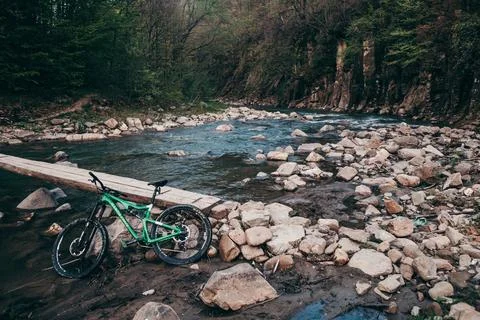 A bicycle parked on the side of a river Stock Photos