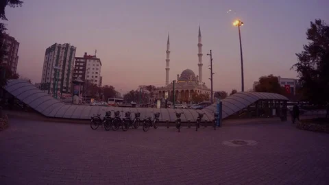 Bicycle parking in the evening, mosque and minarets, high-rise modern houses in Stock Footage 82293771