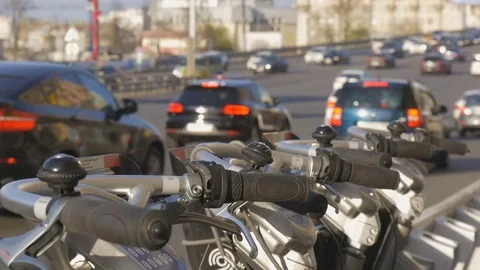 Bicycle parking, next to the road. On which a large traffic cars. Alternative Video stock 75382784