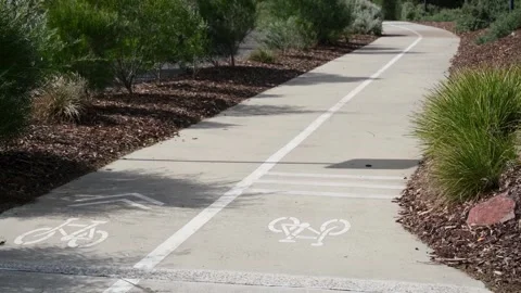 Bicycle path featuring white painted bicycle symbols and median dividing line Vídeos de archivo 336034515