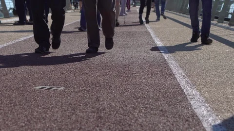 Bicycle path on a pedestrian bridge with white marking lines. Pedestrians walk Stock Footage 108776798