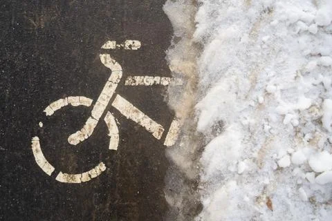 Bicycle path in winter under the snow. The bike season is closed due to ice. Stock Photos