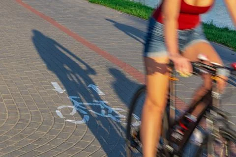 Bicycle rider and shadow on cycle path with bicycle sign in motion blur effec Stock Photos