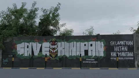 Bicycle riders passing through paint graffiti art, Save Kinipan Stock Footage 136425164