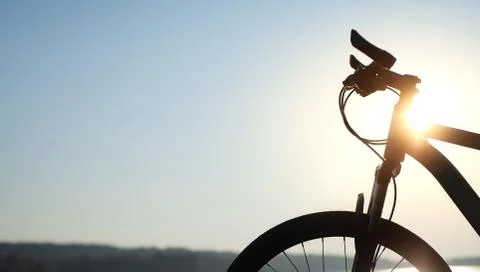 Bicycle by the river on a sunset background. Stopping on a bike ride. Leisure Stock Photos