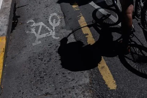 Bicycle shadow making proper use of the bicycle lane Stock Photos