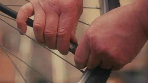 Bicycle tyre pump, hands pumping tyre on a vintage bike, repair and maintenance Stock-Footage 287208606