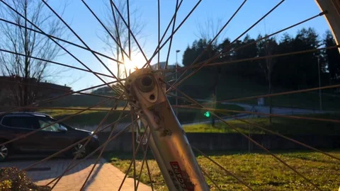 Bicycle wheel spinning with sun into rays Stock Footage 127600626