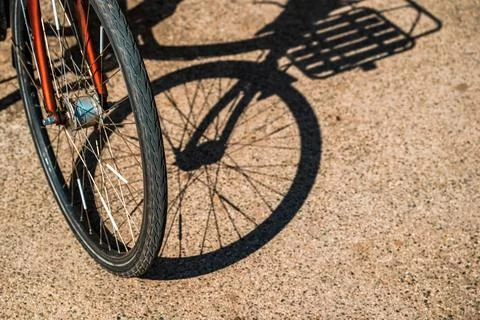 Bicycle wheels and frames casting graphic shadows on ground, cycling and su.. Stock Photos
