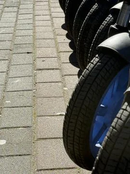 Bicycle wheels casting shadows on pavement create dynamic urban background .. Stock Photos
