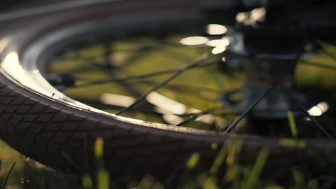 Bicycle wheels lying on green grass close up. Bicycle lying on grass Stock Footage 80858804