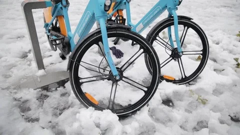 Bicycle wheels in snow after high snowfall in Jerusalem. Rental idle bikes Stock Footage 170611552