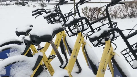 Bicycles covered with snow stand during a snowfall Stock Footage 225525804