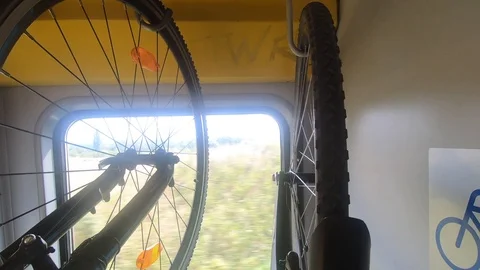 Bicycles hanging on rack in moving train, bike sign on wall Stock Footage 114649438