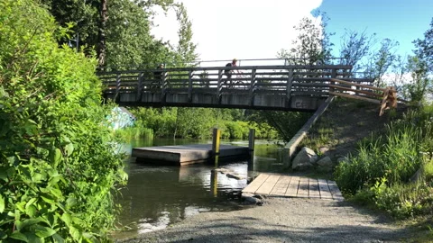 Bicycles ride over stream bridge Stock Footage 146991137