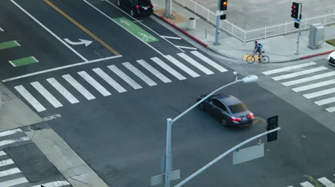 Bicyclist crossing the zebra walk seen from above in Los Angeles Stock Footage 59458902