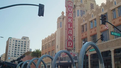 Bicyclist rides by Oakland Fox Theater Sign, Oakland California Stock Footage