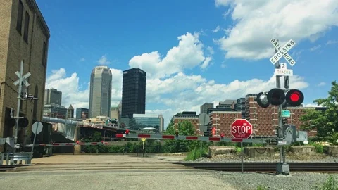 Bicyclists Wait for Train to Pass Before Crossing Tracks Stock Footage