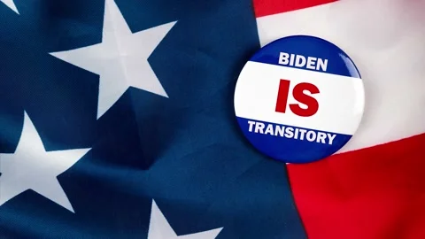 Biden is transitory text quote on election button laying on the star spangled Video stock 170629871