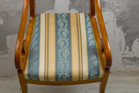 Biedermeier-style armchair in a room setting with a textured wall and wooden  Stock Photos