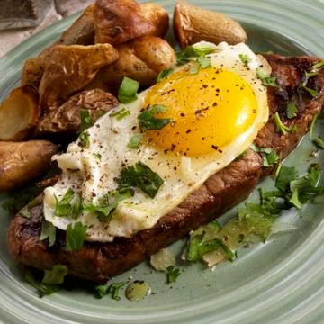 Bife a Cavalo; Brazilian Steak Topped with a Fried Egg; Potatoes Stock Photos