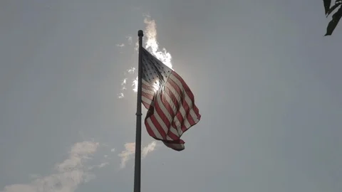 Big American Flag Waving in Clear Sky Infront of Sun Stock Footage 100850159