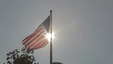 Big American Flag Waving in Clear Sky Infront of Sun Stock Footage 100850189