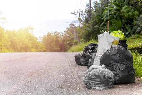 Big and many plastic garbage bag on streets with garbage sitting on ground Stock Photos