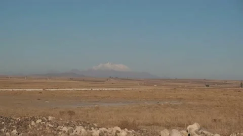 A big and single snow-capped mountain seen from a car in Anatolia Stock Footage 146029794