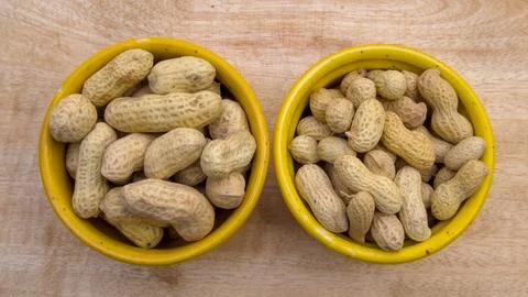Big and Small Peanut Comparison, Two Varieties in Bowls, Top View Stock-Fotos