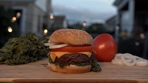 Big appetizing burger with meat cutlet, onion, vegetables, melted cheese and Stock Footage 116918005